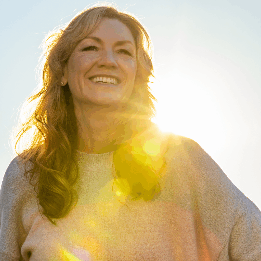 woman smiling with sun on her shoulders