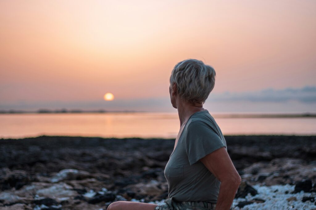 woman staring into the sunset on the beach